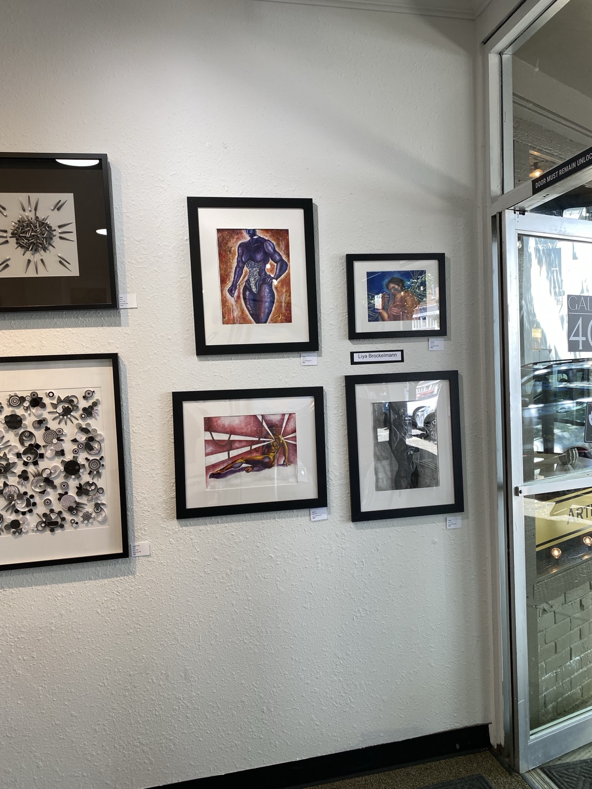 Framed pieces hung near the gallery entrance at Gallery 408